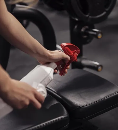 staff disinfecting gym equipment